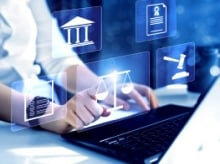 hands on a laptop with floating legal symbols on tiles in front of the screen